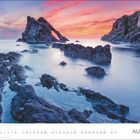 August-Kalenderblatt mit eindrucksvoller Küstenlandschaft, Felsen im Wasser und farbenfrohem Himmel bei Sonnenuntergang.