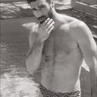 08. Kalender mit einem Mann in Badehose, am Wasser, nachdenklich, mit Bart. Schwarzweiß-Fotografie.