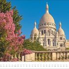 Kalender für August. Einladendes Bild der Sacré-Cœur-Basilika. Blühende pinke Bäume im Vordergrund, blauer Himmel.