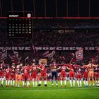 Kalender für August, Logo eines Fußballvereins. Team in roten Trikots vor jubelnden Fans im Stadion.