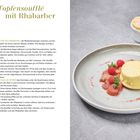 "Topfensoufflé mit Rhabarber" steht in grünem Text. Links ist ein Rezept, rechts ein Teller mit Soufflé, Himbeeren und Rhabarber.