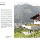 "Gläserner Anbau am Bauernhof", Text über moderne Architektur in Südtirol. Foto: Bauernhof mit Glas-Erweiterung, Berge im Hintergrund.
