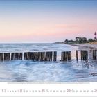 August 2023. Küstenlandschaft bei Sonnenuntergang mit Holzpfählen im Wasser und einem Leuchtturm im Hintergrund.