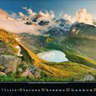 Kalenderseite für August 2021. Eine Gebirgslandschaft mit See, umgeben von grünen Hügeln und schneebedeckten Bergen.