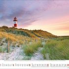 Monat August 2024, rot-weißer Leuchtturm auf einer Düne bei Sonnenaufgang, umgeben von Sand und hohen Gräsern.