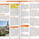 Texte: "MALLS & MÄRKTE", "SHOPPEN & STÖBERN", "ludwig.de!). Der historische", "Café mit Grandezza".

Beschreibung: Eine textreiche, zweiseitige Zeitschriftenseite mit farblich hervorgehobenen Kategorietiteln und Absätzen. Rechts sind Markt- und Einkaufsinformationen, links ein Bild von einer belebten Außenszene mit Tischen und Pflanzen.