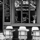 "Restaurant", Menü mit Getränken, Tisch mit Stühlen außen, Kalender unten mit Monat August, Zitat über Paris von Henri Calet.