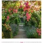 08. Ein Gartenpfad führt durch ein Blumentor aus Rosen, umrahmt von üppigem Grün und bunten Blüten.