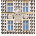 Kalender, Woche 4, Januar 2027. Bild von vier Fenstern auf geometrisch gestaltetem Gebäude mit verziertem Wappen.