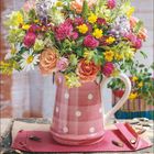 8 | 2027. Zahlreiche bunte Blumen in einer rosa gepunkteten Vase, darunter Rosen, Kamille, Rotklee und gelbe Blüten.