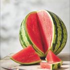 „August“ und Kalenderdaten unten, eine aufgeschnittene Wassermelone mit leuchtend rotem Fruchtfleisch auf einem Tisch.