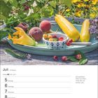 Juli, 27. Woche, Krebs 21.6.–22.7. Bild: Obst und Zucchini auf einem Teller im Garten, umgeben von grünen Pflanzen.