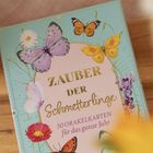 "Zauber der Schmetterlinge. 50 Orakelkarten für das ganze Jahr" umgeben von bunten Schmetterlingen und Blumen.