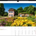 August, Kalender. Ettenheim – Blumenpracht im Prinzengarten. Bunte Blumen vor einem kleinen Gebäude mit Bäumen im Hintergrund.