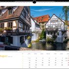 August-Kalenderbild mit Fachwerkhäusern an einem Fluss in einer malerischen Altstadt.