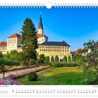 "Schloss Weesenstein im Müglitztal." Kalendermonat August. Eine Schlossanlage mit gepflegtem Garten unter klarem Himmel.
