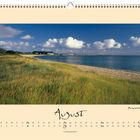 Kalenderblatt: August. Foto von Munkmarscher Bucht. Sandstrand mit Gras, blauer Himmel, einige Wolken, ruhiges Meer.