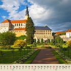 08, Kalender mit August-Tagen, Ansicht eines großen klassischen Gebäudes mit roten Dächern und einem gepflegten Garten.