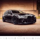 Text: "BMW M3 Touring (G81)", "JULI". Ein schwarzes Auto mit sportlichem Design, parkend auf einem asphaltierten Platz.
