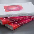 Drei Bücher mit dem Titel "Sehnsucht nach Leben" von Margot Käßmann, in Rot- und Weißtönen, liegen gestapelt.