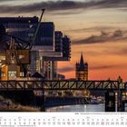 "Köln - Rheinauhafen mit Kranhäusern und Blick nach Groß St. Martin." Kalenderseite August 2027, Sonnenuntergang.