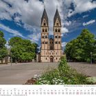 Kalenderblatt: Monat August 2027. Ein großes Gebäude mit zwei Türmen steht vor einem blauen Himmel mit Wolken.