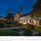 Kalenderseite August 2027, mit einem beleuchteten Schloss und einer Kirche bei Nacht. Der Vordergrund zeigt einen gepflegten Friedhof.