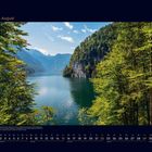 08 August, Kalender mit einem See inmitten grüner Berge, umgeben von Bäumen.