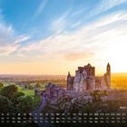 Text: "Rock of Cashel 8". Eine Burg auf einem Hügel bei Sonnenaufgang, umgeben von üppiger grüner Landschaft.