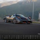 Text: "Pagani Huayra 8". Ein Sportwagen fährt auf einer kurvigen Bergstraße, umgeben von Hügeln.