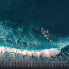Kalender August-Wochen mit 1.-31., darüber Meereswellen mit weißem Schaum auf tiefblauem Wasser.