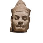 Eine antike Steinskulptur eines Kopfes mit detailreichen Gesichtszügen und traditionellem Kopfschmuck.