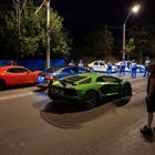 Auf der Straße stehen Autos, darunter ein grüner Sportwagen. "Politia" steht auf den Polizeiautos, daneben Polizisten.