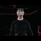 Keine erkennbaren Texte. Ein Mann trägt eine VR-Brille, umgeben von leuchtenden, roten Linien auf schwarzem Hintergrund.