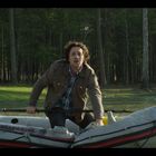 Der Text "MARINER 4" ist auf einem Schlauchboot zu sehen. Ein Mann rudert auf einem See vor einem Wald.