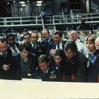 Mehrere Menschen, teils in Uniformen, stehen in einem Kontrollraum um einen Tisch, besorgt und konzentriert.