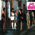 Text: "Liebe gegen Barzahlung" oben rechts. Fünf Frauen stehen nächtlich gekleidet auf einem Bürgersteig, vor Schaufenstern.