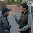 Zwei Männer auf einer Straße in einer Diskussion. Der eine trägt eine Kappe, der andere eine Weste und gestikuliert.