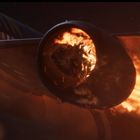 Ein brennendes Triebwerk eines Flugzeugs in Nahaufnahme, Flammen und Funken sichtbar.