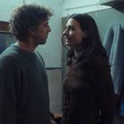 Ich kann keinen Text im Bild erkennen. Ein Mann und eine Frau stehen sich nah gegenüber in einem Raum mit Spiegel.