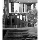 Kalenderblatt mit Datum 9, Wochentagen und einem Foto des Kanzleramts, modern, mit großen Fenstern und weißen Säulen.