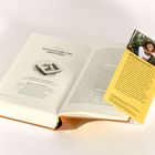 Eine aufgeschlagene Buchseite mit der Überschrift "Zufluchtsort für Abenteuer". Rechts ist eine gelbe Leseprobe eingelegt.