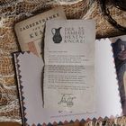 Ein Brief mit der Überschrift "Der 35. jährliche Hexenkongress" liegt auf einem Tisch mit weiteren Papieren und Netzen.