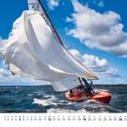 Zahl "9", Kalenderdaten darunter. Segelboot auf bewegtem Wasser unter blauem Himmel mit Wolken.