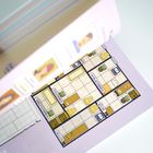 Beschriftete Raum-Illustration: "SCHLAFZIMMER", "KÜCHE", "ESSZIMMER", "ARBEITSZIMMER", "KELLER". Enthält Möbel und Pflanzen.