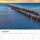 Kalenderblatt für September mit Wochentagen und Datumsangaben. Buhnen führen ins Meer bei Sonnenuntergang.