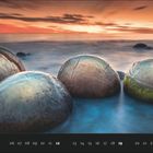 Kalenderseite September. Fünf große, runde Felsen im Wasser bei Sonnenuntergang am Meer.