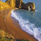 September 2021 Kalenderblatt mit Küstenkulisse. Der Himmel ist blau, das Meer trifft auf einen sandigen Strand neben Felsen.