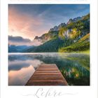 Text: "Die Lehre gleicht ... Lehre." und "Lehre". Ein Steg führt auf einen stillen See zu, umgeben von bewaldeten Bergen bei Sonnenaufgang.