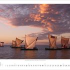 Septemberkalender 2024. Fünf Segelboote auf ruhigem Wasser unter einem dramatisch gefärbten Abendhimmel.